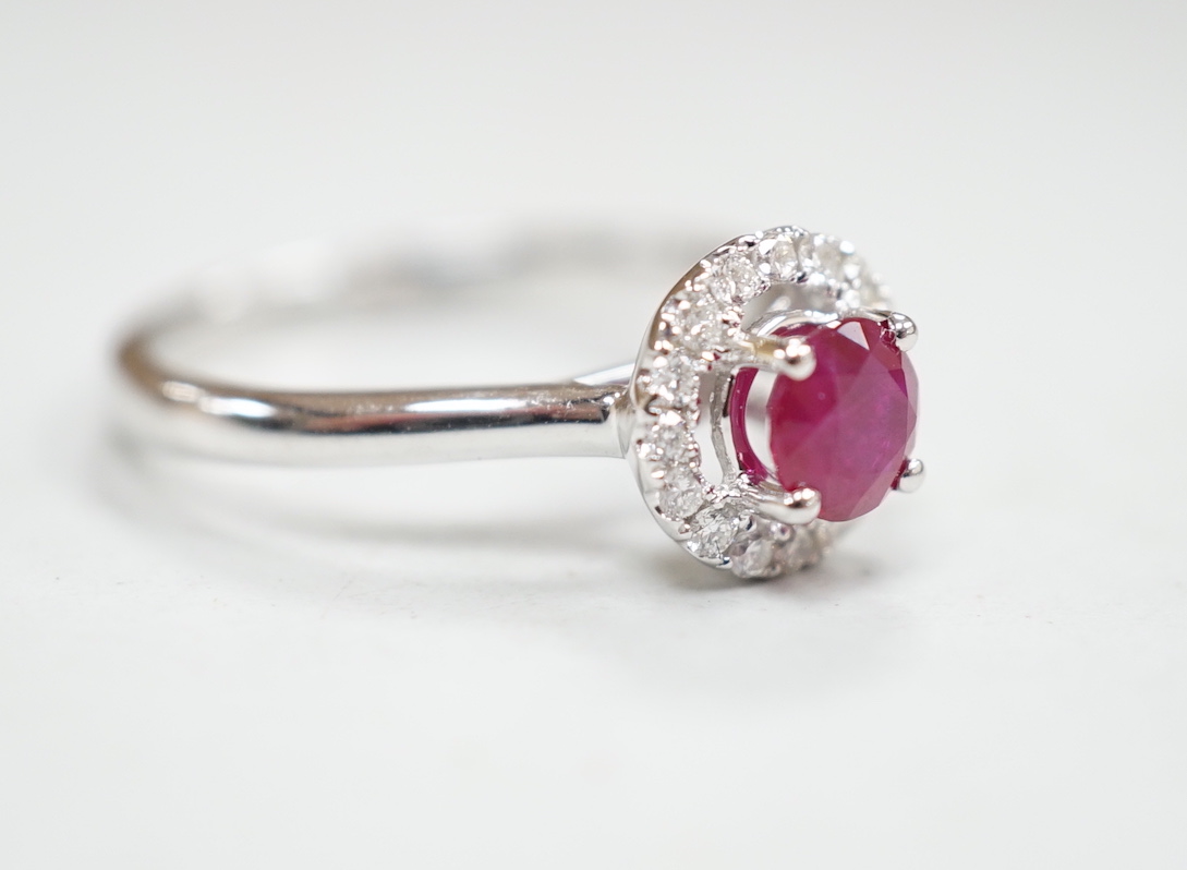 A modern 18ct white gold, ruby and diamond set circular cluster ring, size M, gross weight 3.1 grams.